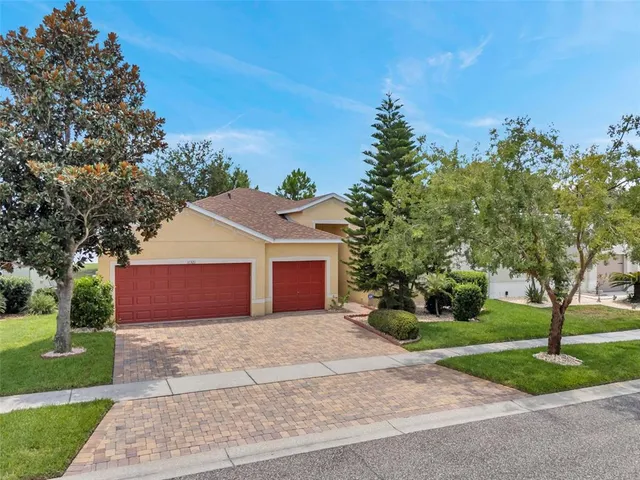 a front view of a house with a yard and trees