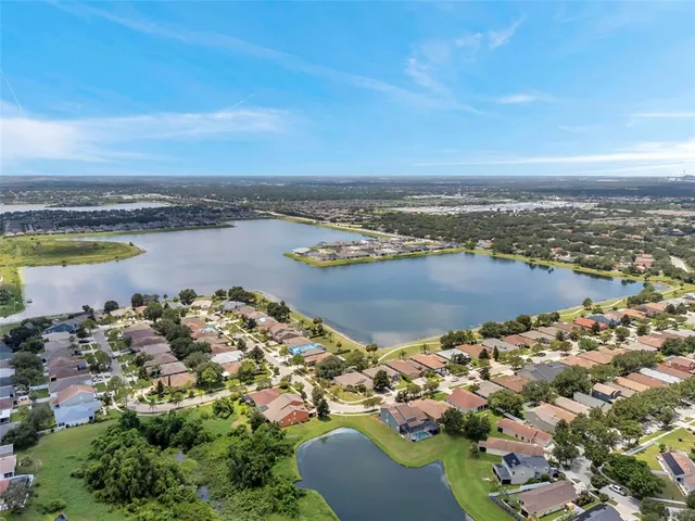 an aerial view of ocean and residential houses with outdoor space
