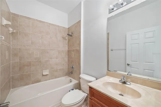 a bathroom with a bathtub shower sink mirror vanity and a toilet