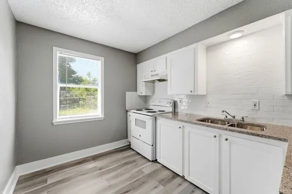 a kitchen with a sink stove and cabinets