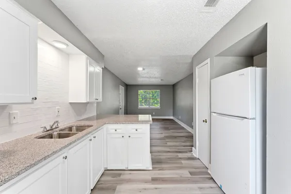 a kitchen with a refrigerator sink and cabinets