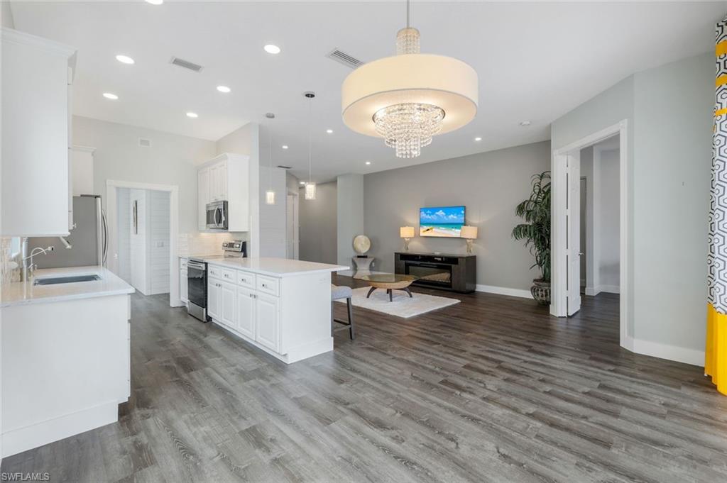 4648 Rio Poco Court Naples, FL 34109 - Photo 27 of 27 Kitchen with a sink, stainless steel appliances, open floor plan, wood finished floors, and recessed lighting