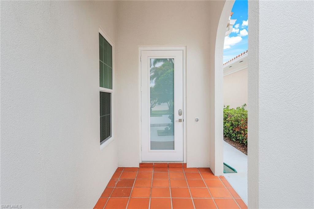 4648 Rio Poco Court Naples, FL 34109 - Photo 12 of 27 Entrance to property with Impact door and glass. Stucco siding.