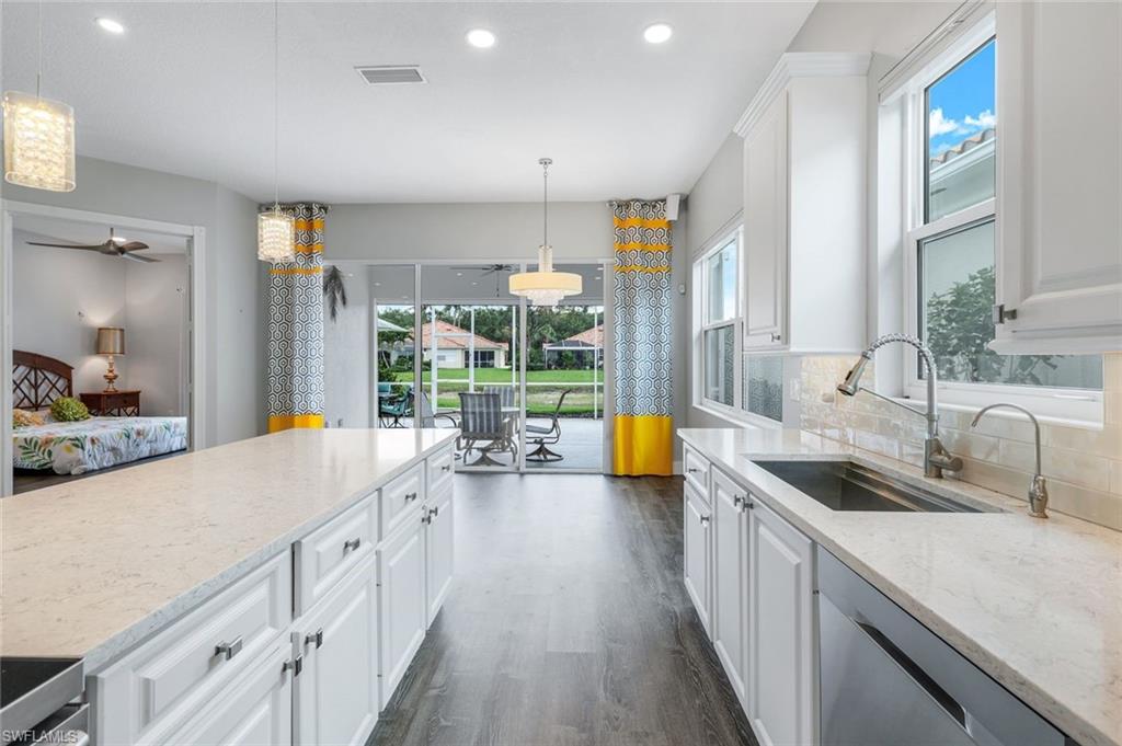4648 Rio Poco Court Naples, FL 34109 - Photo 14 of 27 Kitchen featuring dishwasher, a sink, dark wood-style luxury vinyl floors, white cabinetry, and recessed lighting