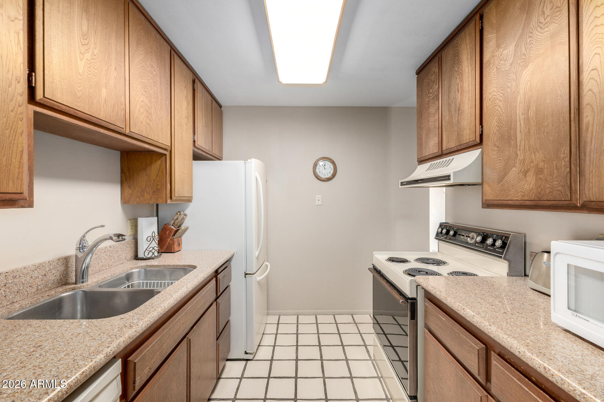 5525 East Thomas Road, Unit H7 Phoenix, AZ 85018 - Photo 9 of 27 a kitchen with a sink a stove and cabinets