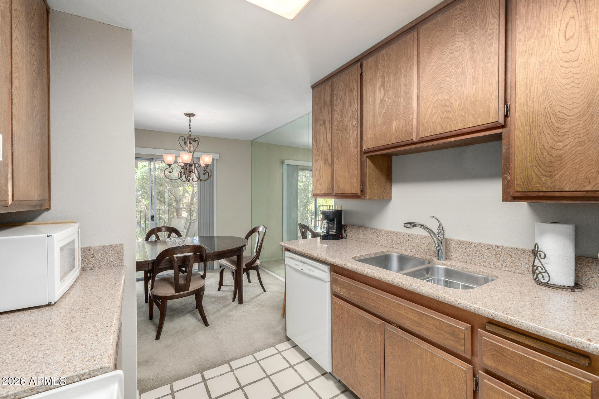 5525 East Thomas Road, Unit H7 Phoenix, AZ 85018 - Photo 10 of 27 a kitchen with granite countertop a sink cabinets and window