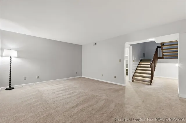 a view of an empty room with stairs and ventilation