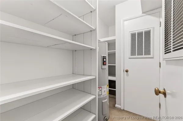 a view of room with walk in closet and wooden floor