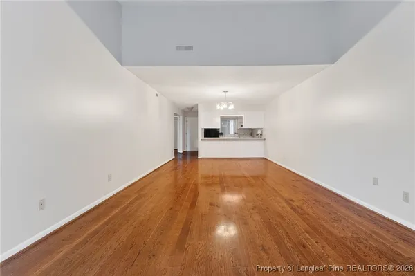 a view of empty room with wooden floor