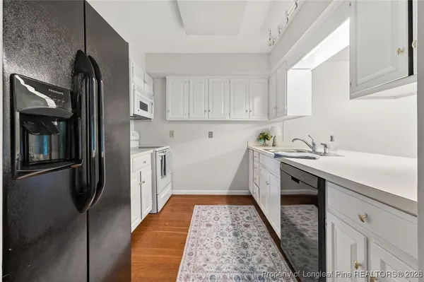 a kitchen with a sink a refrigerator and cabinets