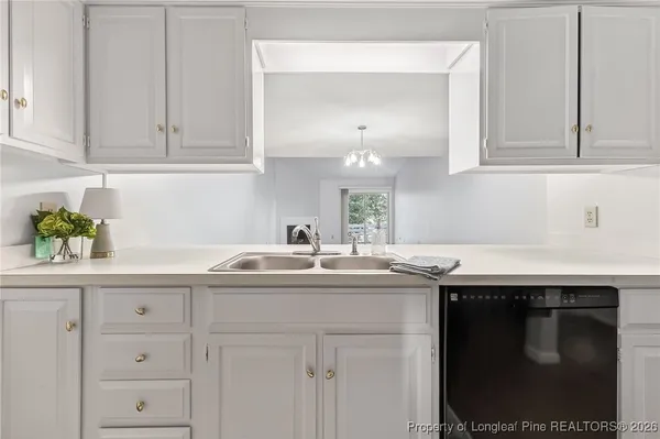 a kitchen with white cabinets and sink