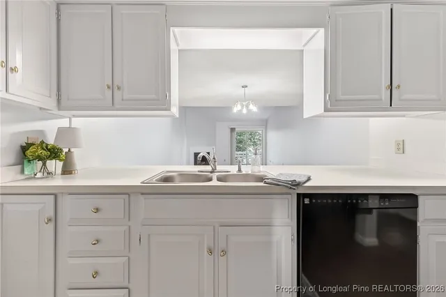 a kitchen with white cabinets and sink