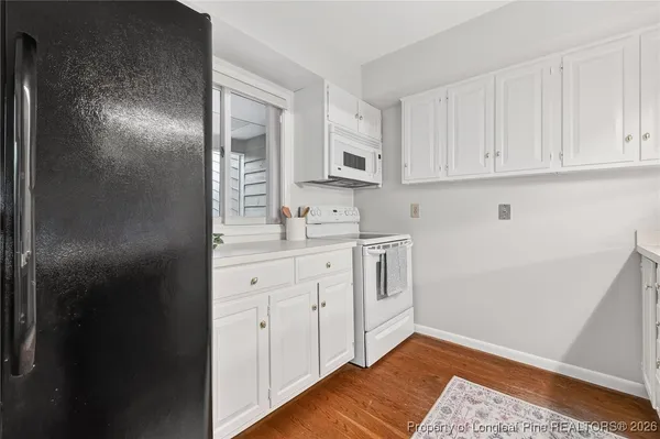 a kitchen with white cabinets and sink