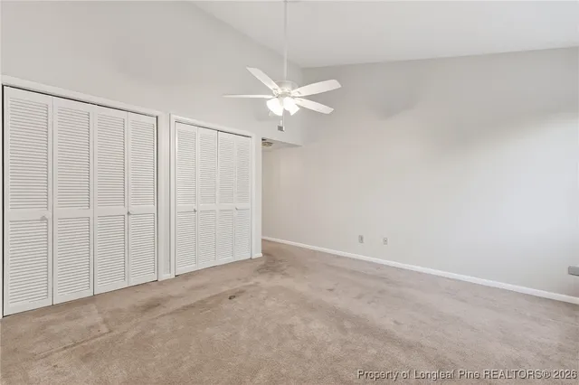 an empty room with a ceiling fan and a window