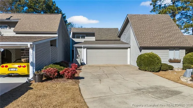 an aerial view of a house with outdoor space and trees all around