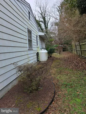 a view of a backyard with large tree and wooden fence