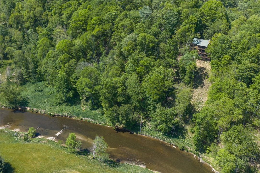 850 River Ridge Road Boone, NC 28607 - Photo 2 of 26 a view of a lake with a yard and large trees