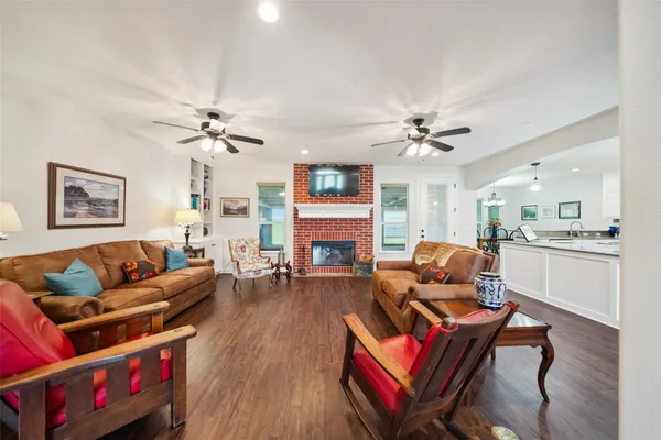 a kitchen with stainless steel appliances granite countertop a stove a sink a refrigerator white center island and couches