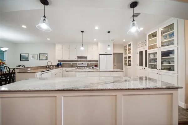 a kitchen with granite countertop a refrigerator and a sink