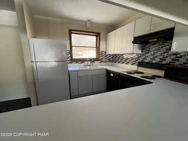 a kitchen with stainless steel appliances a refrigerator sink and wooden cabinets