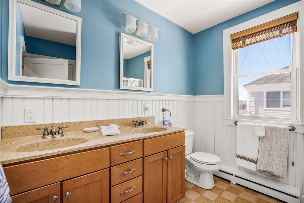 75 Surfside Road Scituate, MA 02066 - Photo 16 of 25 a bathroom with a sink a toilet and a mirror