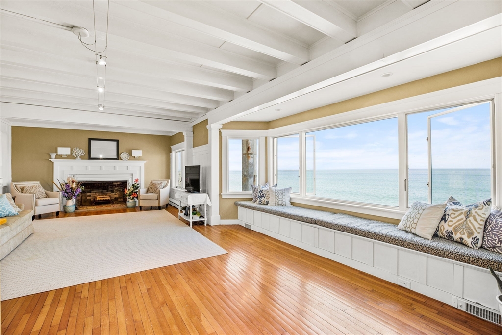 75 Surfside Road Scituate, MA 02066 - Photo 6 of 25 a living room with furniture and a fireplace with wooden floor