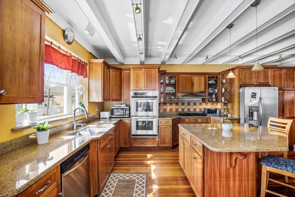 75 Surfside Road Scituate, MA 02066 - Photo 9 of 25 a kitchen with stainless steel appliances granite countertop a sink a counter space stainless steel appliances cabinets and a large window