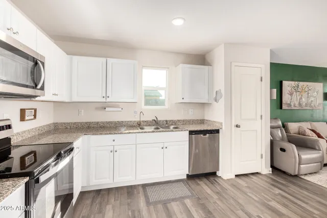 a kitchen with stainless steel appliances granite countertop a stove a sink and a microwave