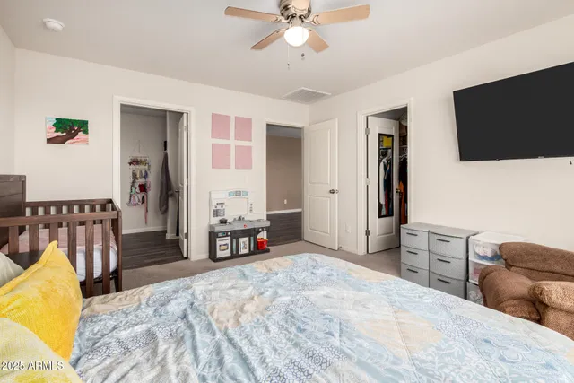 a spacious bedroom with a bed and a flat screen tv