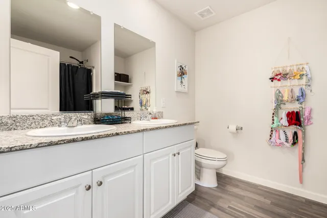a bathroom with a granite countertop sink mirror vanity and toilet