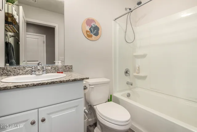 a bathroom with a granite countertop sink a toilet and a bathtub