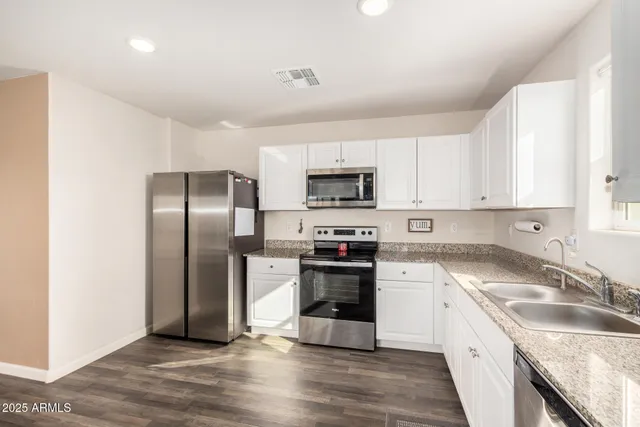 a kitchen with granite countertop a refrigerator sink and stove
