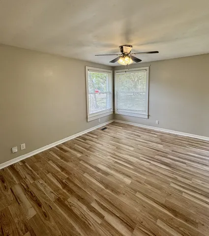 wooden floor in an empty room with a window