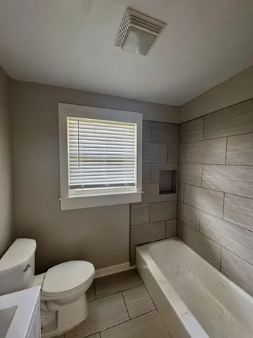 a bathroom with a toilet a sink and bathtub