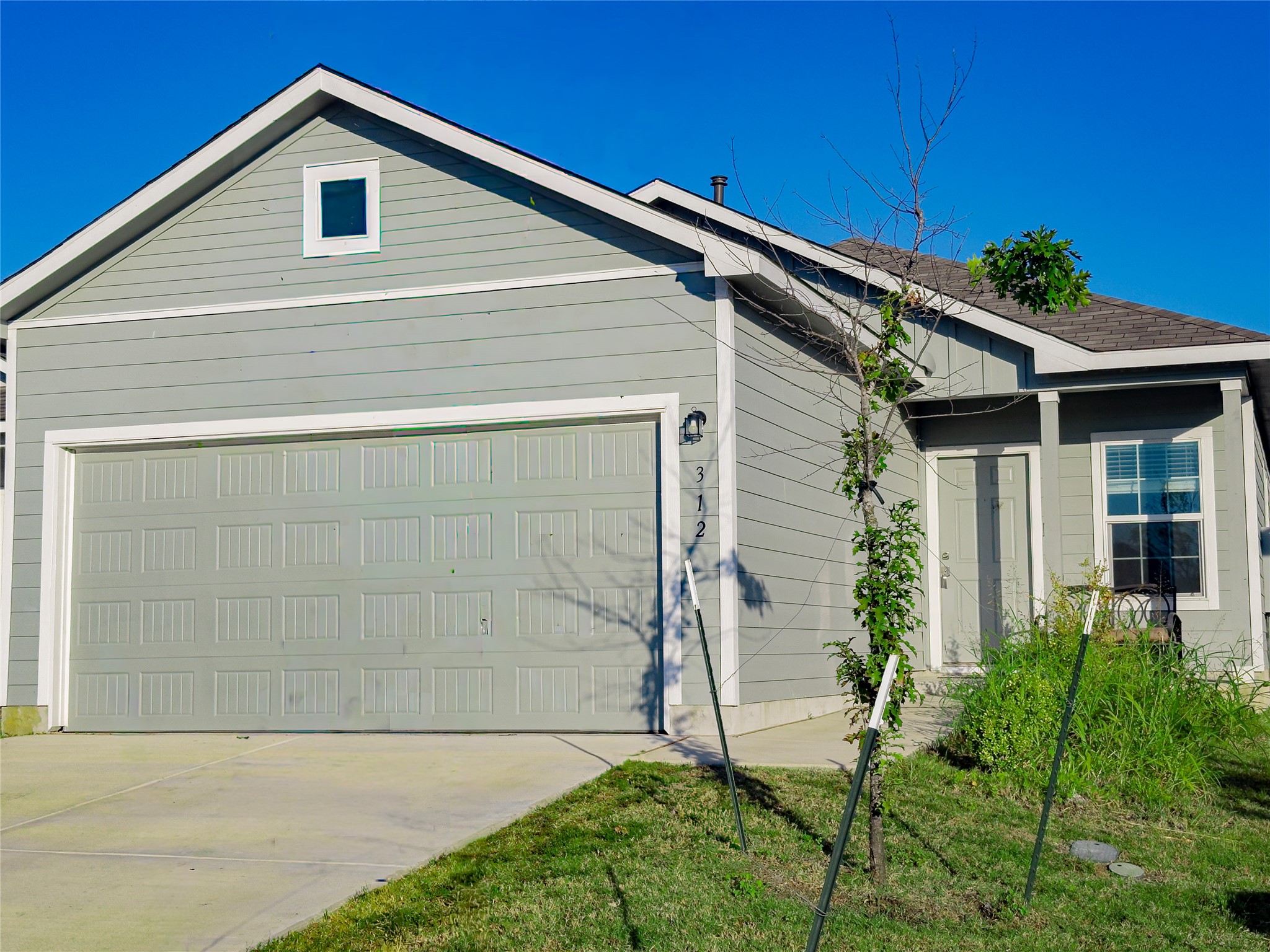 Light gray siding exterior with a dark shingle roof