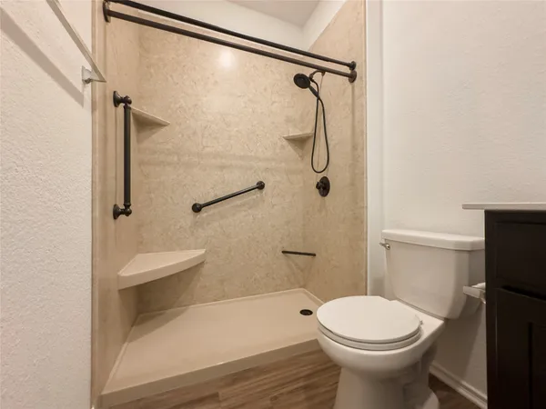 a bathroom with a sink a toilet and shower