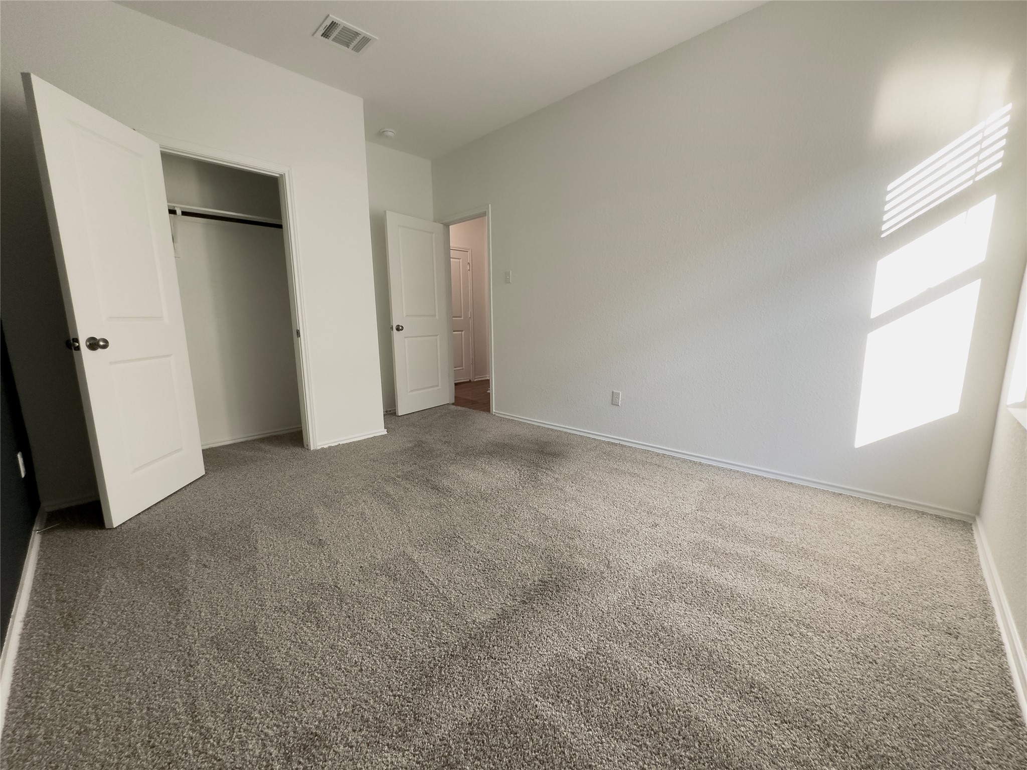 312 Soapstone Pass Maxwell, TX 78656 - Photo 17 of 21 Spacious room featuring neutral carpet flooring, white walls, and bright window with horizontal blinds