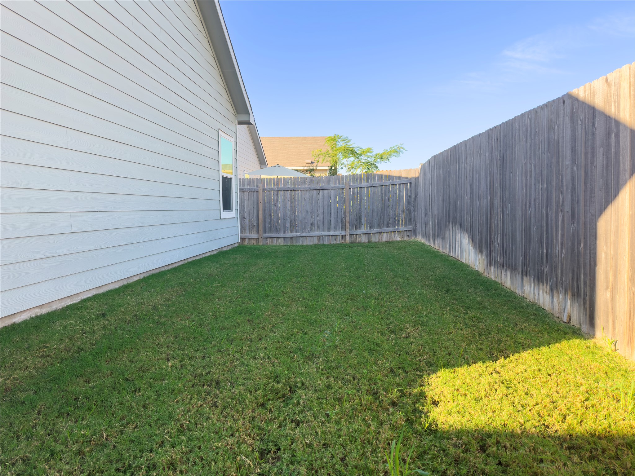 312 Soapstone Pass Maxwell, TX 78656 - Photo 21 of 21 Expansive side yard featuring a manicured lawn, a privacy fence, and horizontal siding