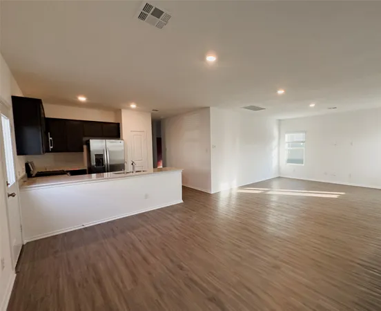 a view of kitchen with kitchen island microwave and wooden floor