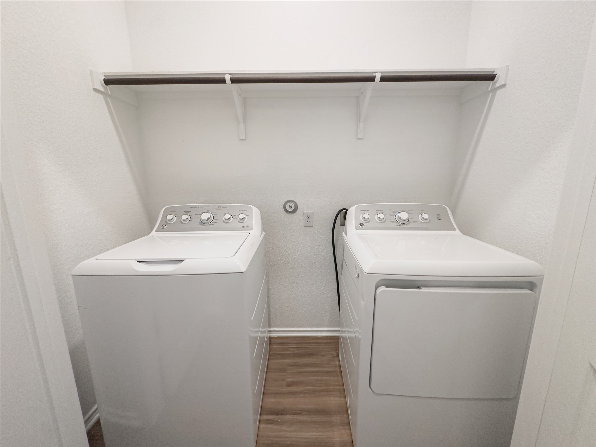 312 Soapstone Pass Maxwell, TX 78656 - Photo 6 of 21 Dedicated laundry area featuring wood-finish flooring and a convenient storage shelf with hanging rod