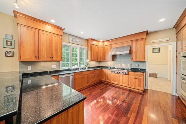 a kitchen with stainless steel appliances granite countertop a sink window and cabinets