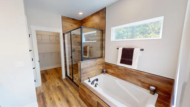 a bathroom with a tub and a large mirror
