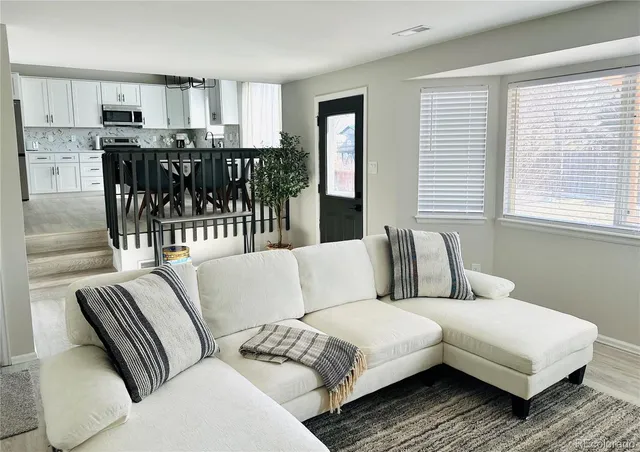 a living room with furniture and view of kitchen