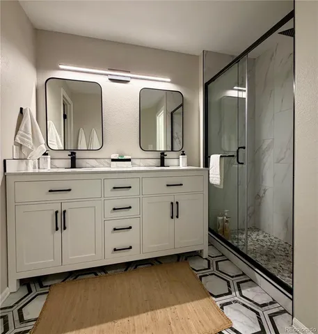 a bathroom with a double vanity sink mirror and shower