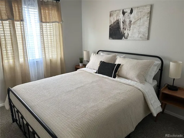 a large bed sitting in a bedroom next to a window