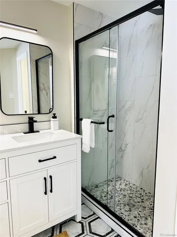 a bathroom with a double vanity sink mirror and shower