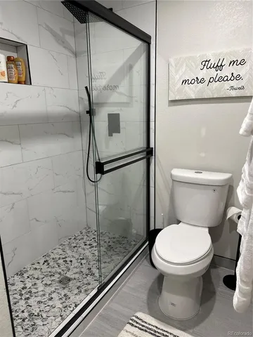 a kitchen with a sink dishwasher a stove and white cabinets with wooden floor