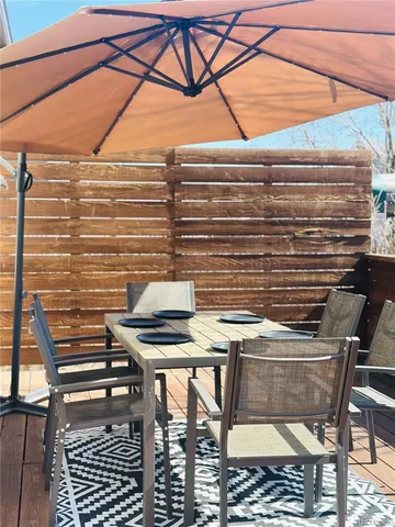 a view of a patio with table and chairs with wooden fence