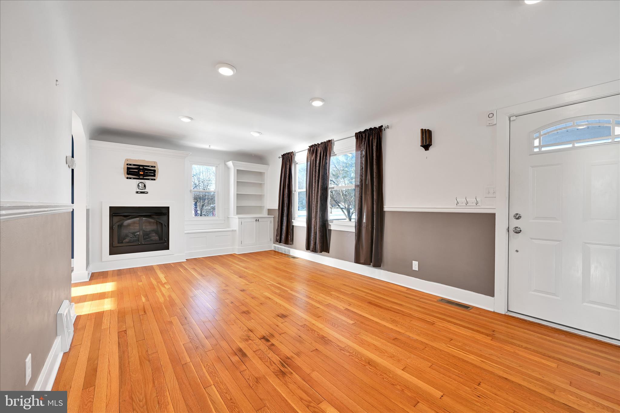 104 Locust Street Annville, PA 17003 - Photo 8 of 43 a view of empty room with wooden floor and fireplace