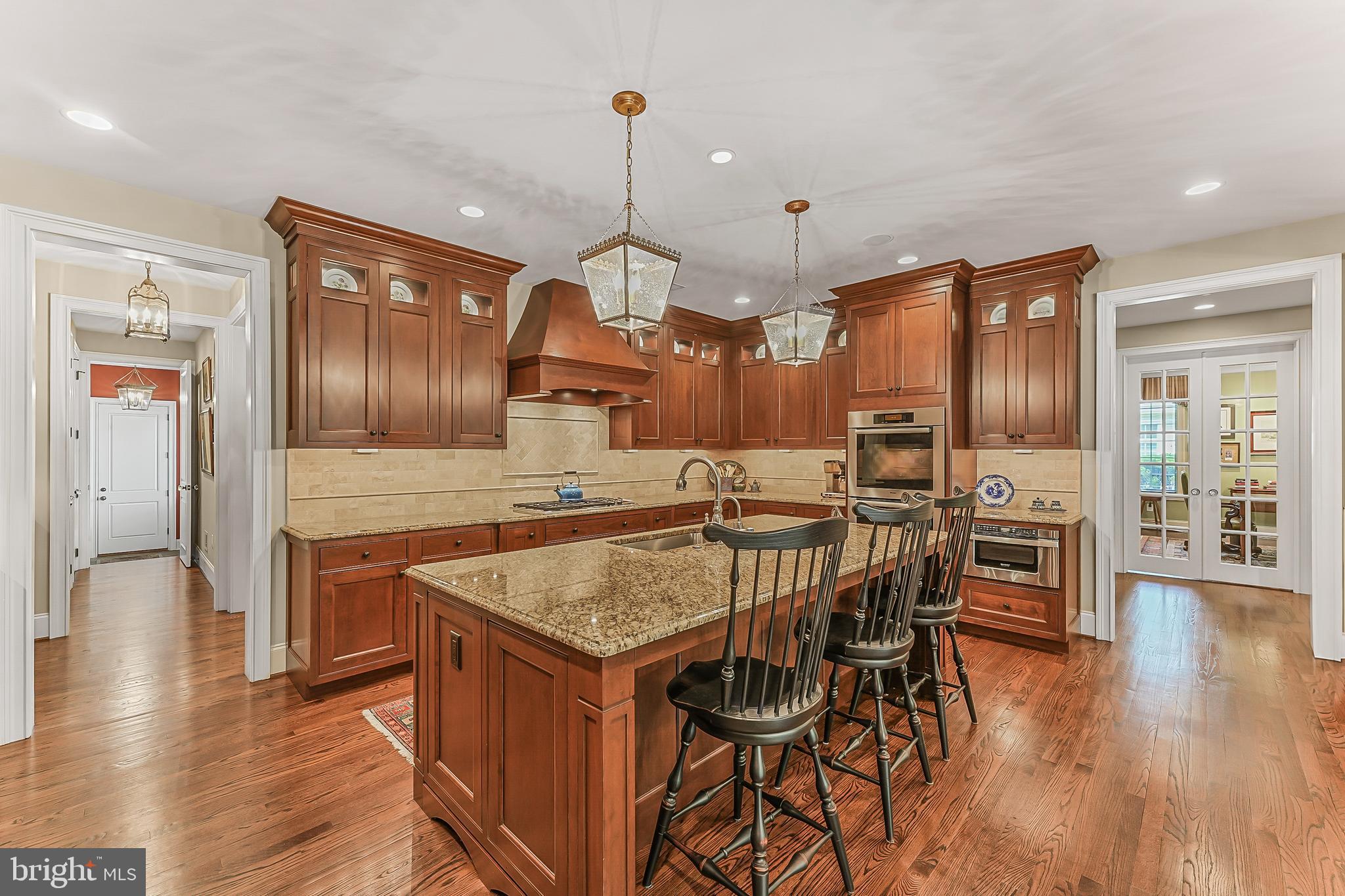 217 Valley Ridge Road Haverford, PA 19041 - Photo 10 of 49 a kitchen with stainless steel appliances granite countertop a kitchen island a stove and a wooden floors